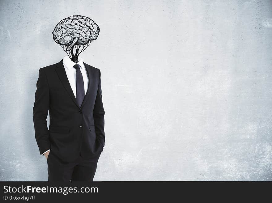 Brain headed businessman on concrete wall background. Brainstorming and success concept