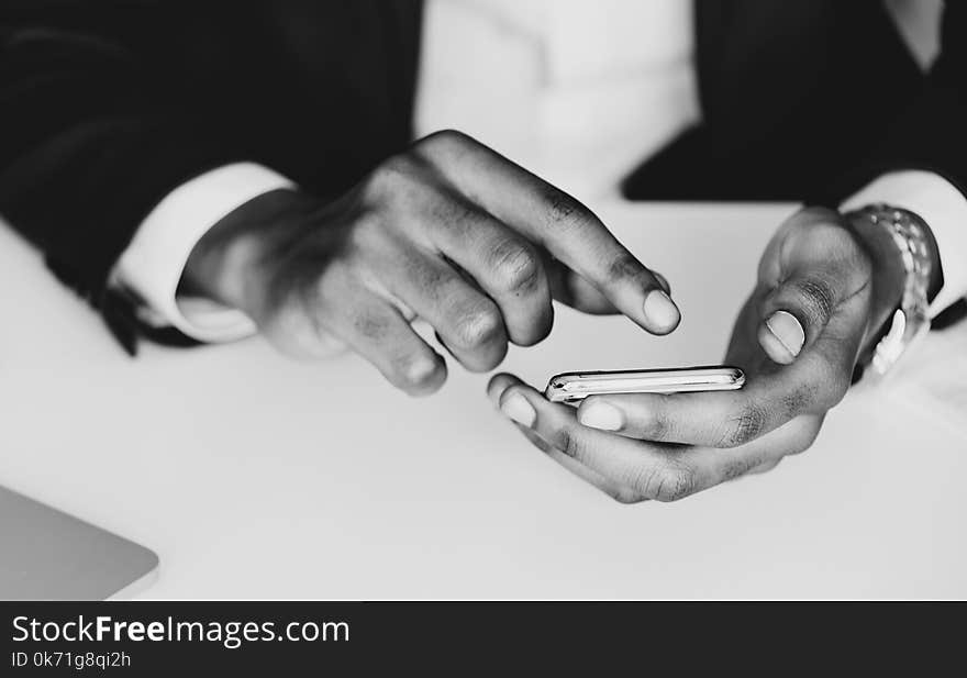 Monochrome Photography of a Person Using Mobile Phone