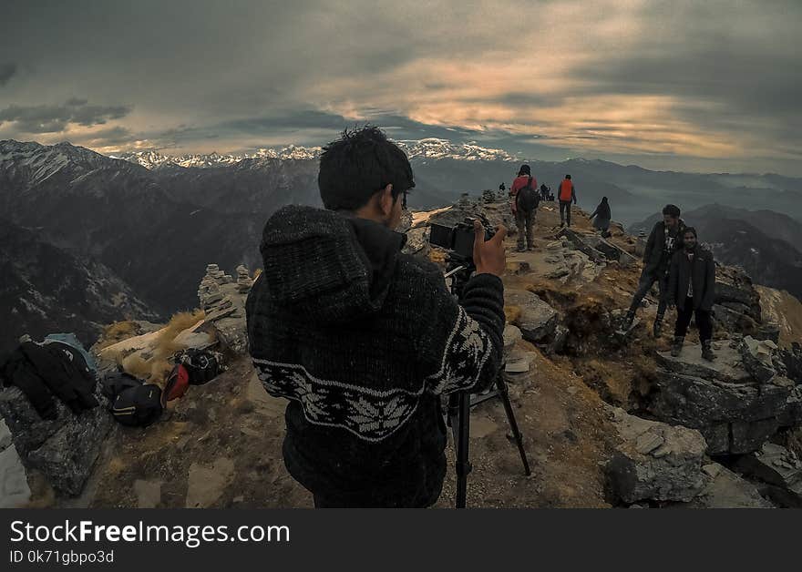 Man Taking Photo of Couple on Mountain Range