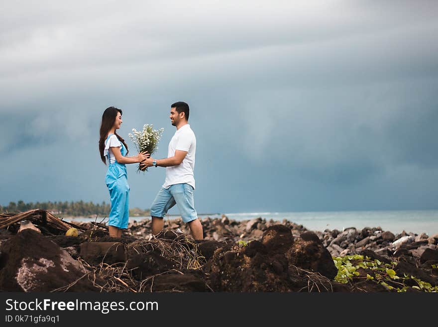 Photo of Man Giving Flowers to Woman