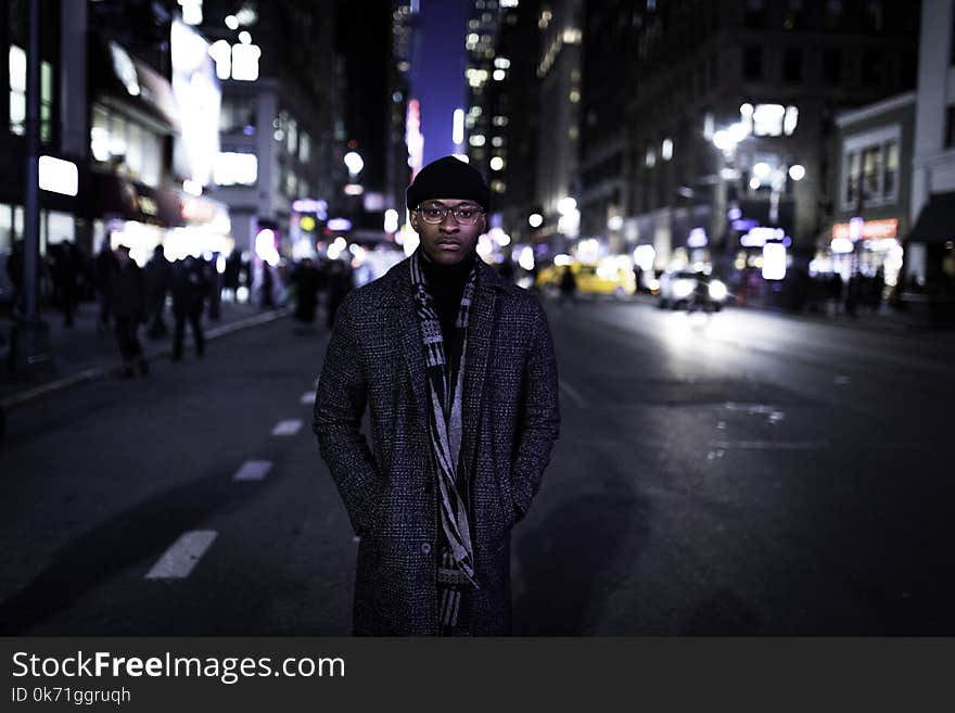 Man Wearing Gray Coat Standing in the Middle of the Road