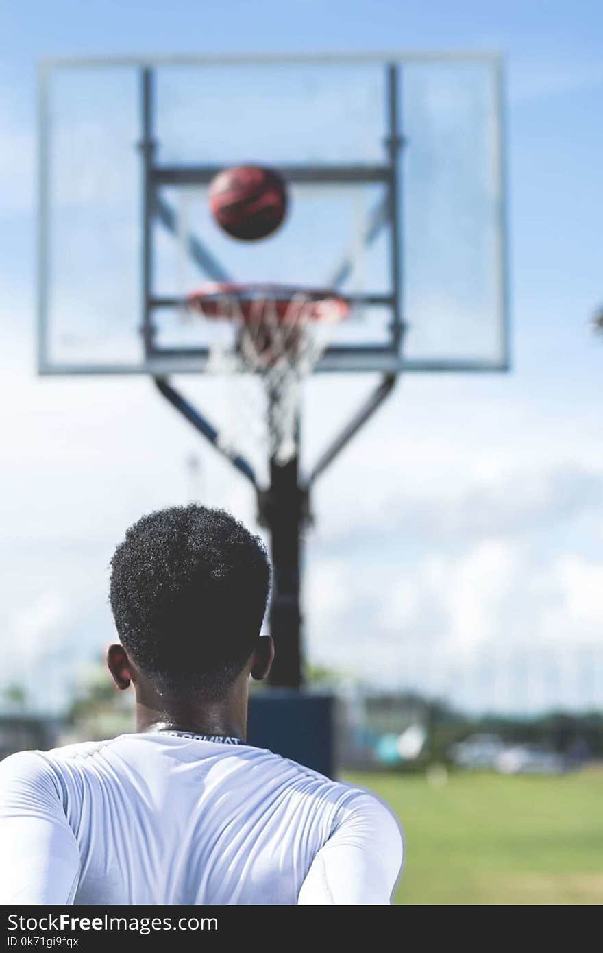 Man Wearing White Long-sleeved Shirt Near Basketball Hoop