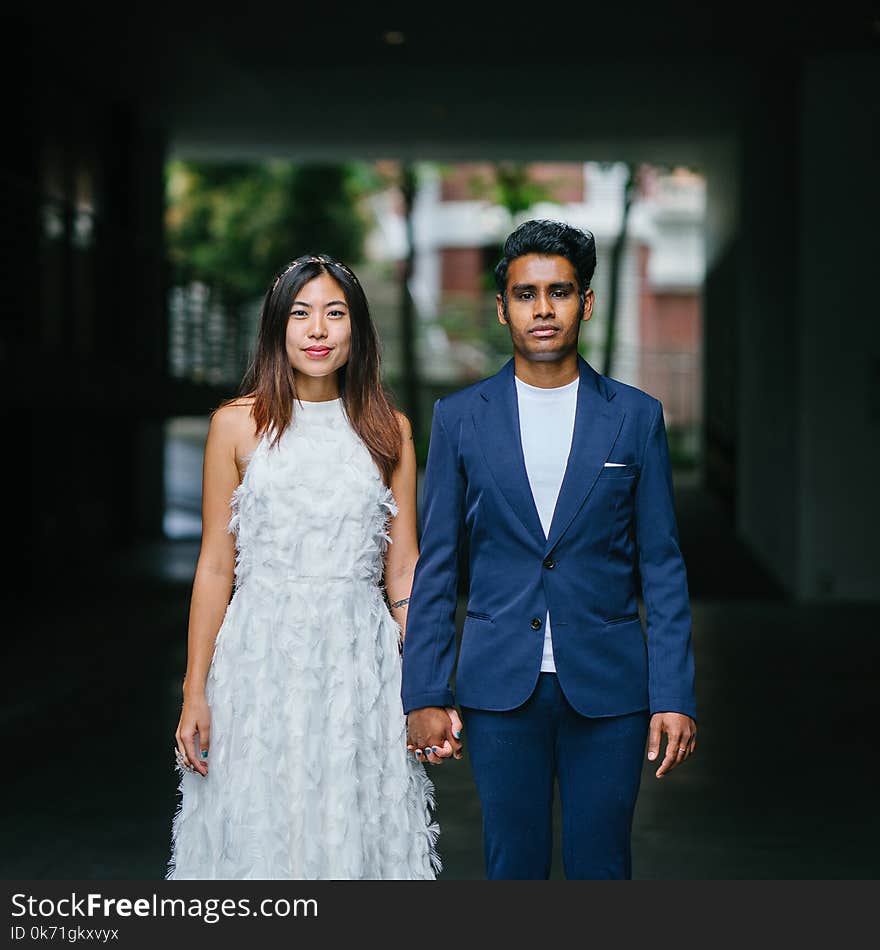 Woman in White Sleeveless Dress and Man on Blue Blazer