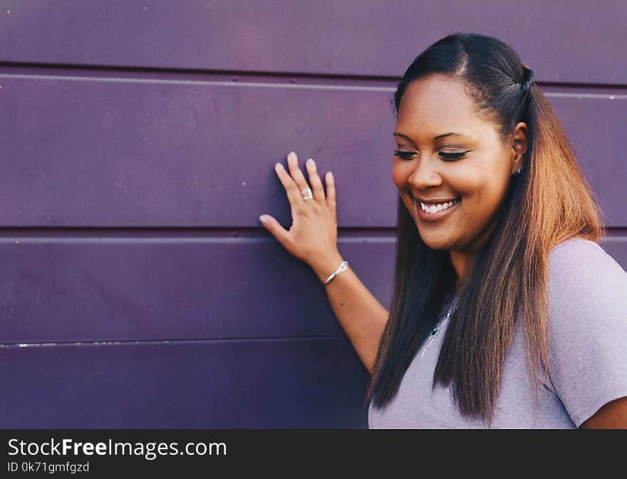 Woman Standing Touching Gray Wall Wearing Gray Shirt