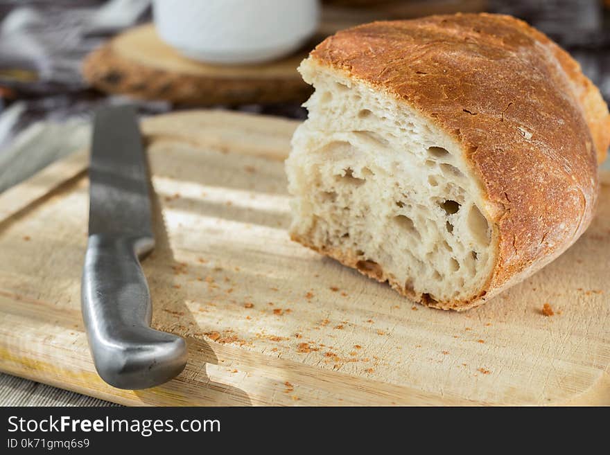 Sliced Bread and Stainless Steel Knife on Top of Brown Wooden Chopping Board