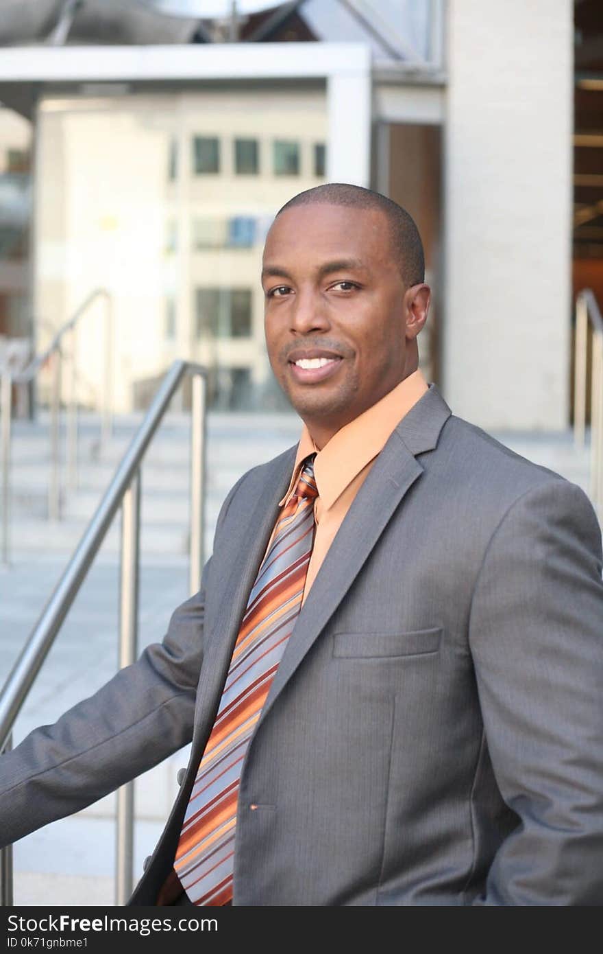 Man Wearing Gray Blazer and Orange Dress Shirt