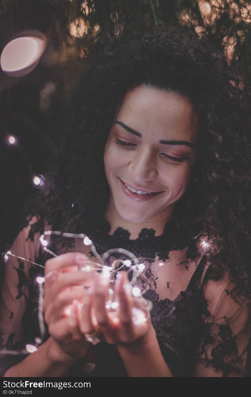 Woman Holding String Lights While Smiling