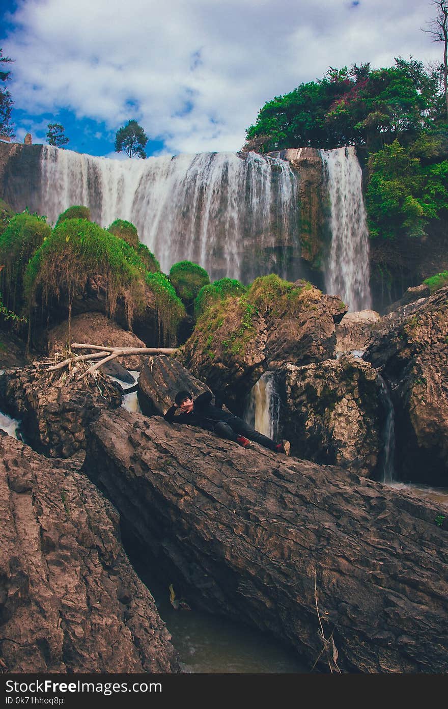 Person Laying on Brown Rock Formation