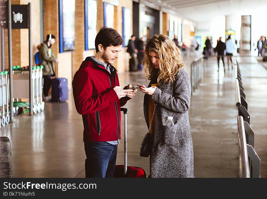 Photo of Man and Woman Using Their Phones