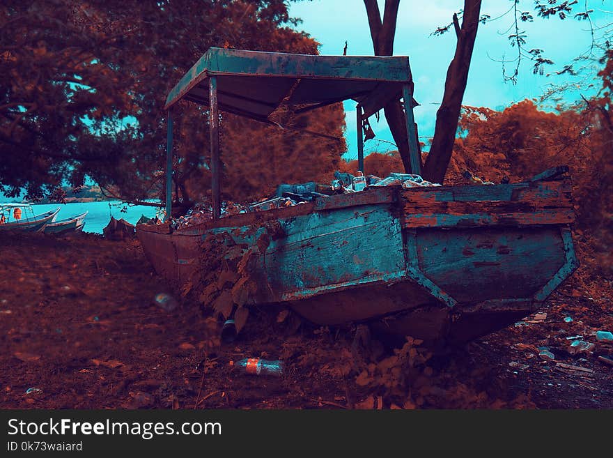 Rusty Brown and Gray Boat Near Trees and Body of Water