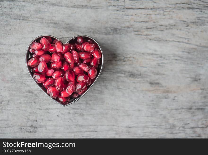 Silver Heart Bowl Filled of Red Pomegranate Seeds