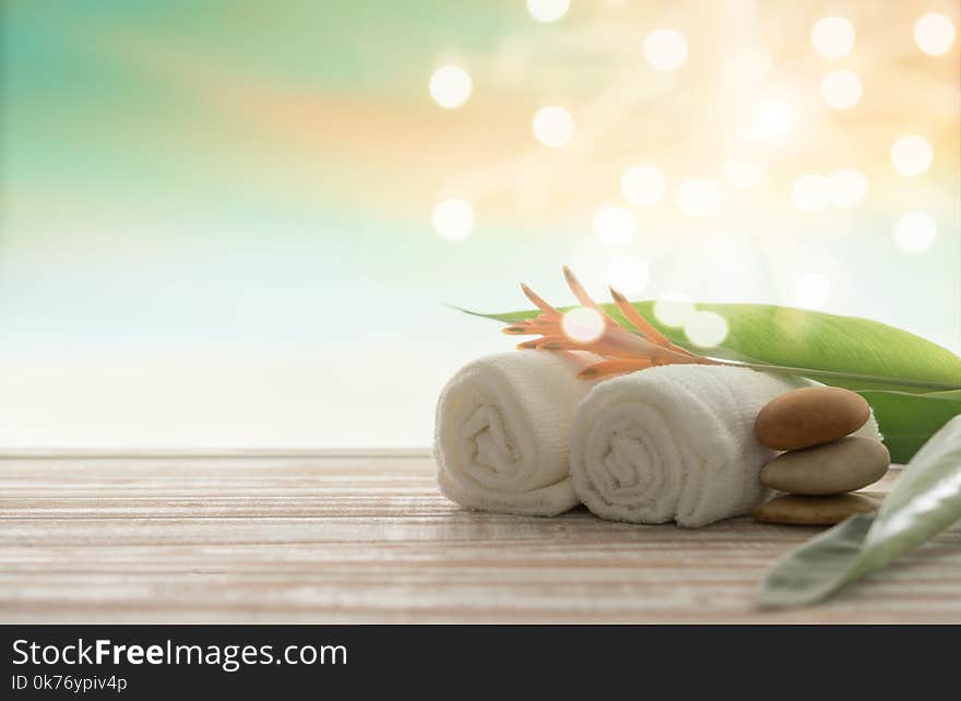 Spa treatment concept. towel,massage oil and spa stones with bokeh nature background. Spa treatment concept. towel,massage oil and spa stones with bokeh nature background.