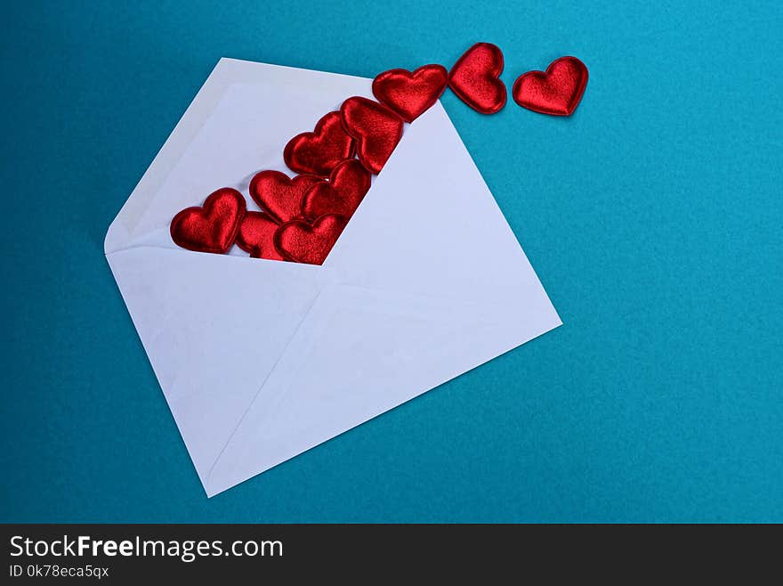 Big white open envelope with red hearts lies on a blue background