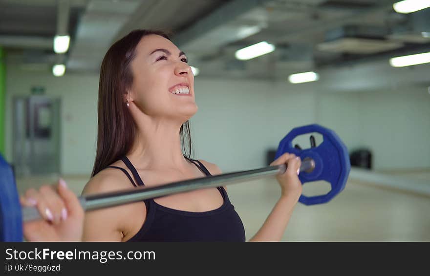 Fitness Concept. Beautiful Brunette Woman Doing Exercises At The Arm With A Barbell