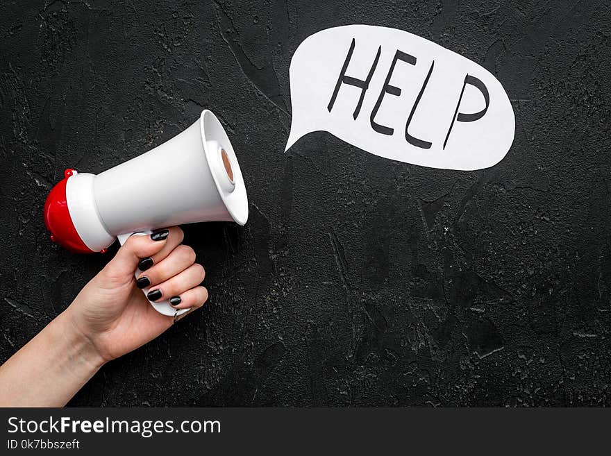 Call for help concept. Megaphone near cloud with word help on black background top view. Call for help concept. Megaphone near cloud with word help on black background top view.