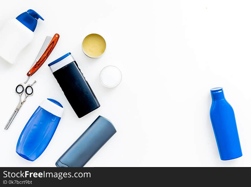 Cosmetics for men`s hair. Bottles with shampoo and gel, tools for brushing, sciccors on white background top view copy