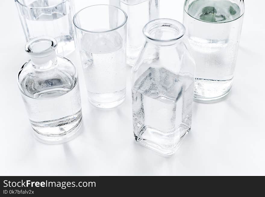 Drinks on the table. Pure water in jar and glasses on white background