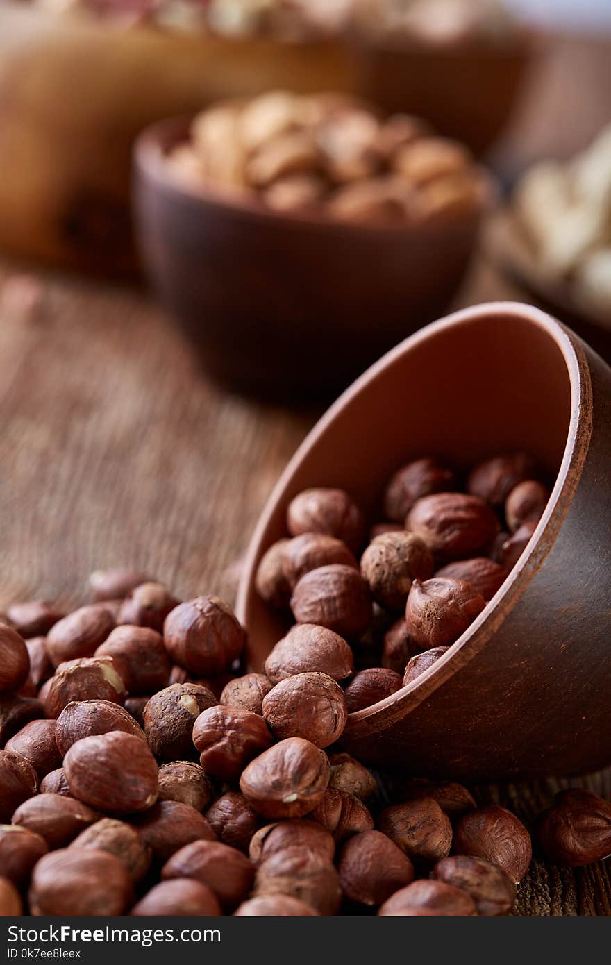 A composition from different varieties of nuts in a wooden bowls on rustic background, close-up, shallow depth of field