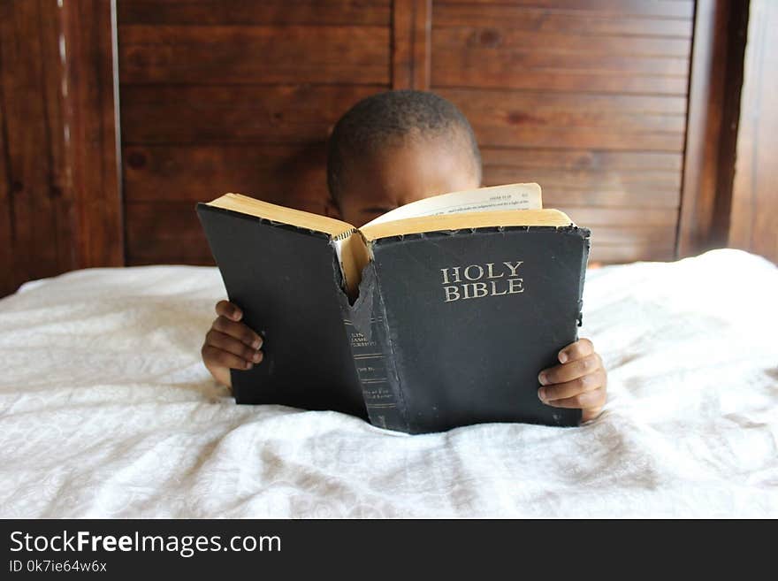 Photo of Child Reading Holy Bible