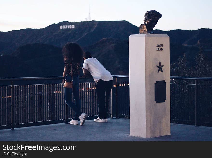 Man and Woman Standing Near Black Metal Railings