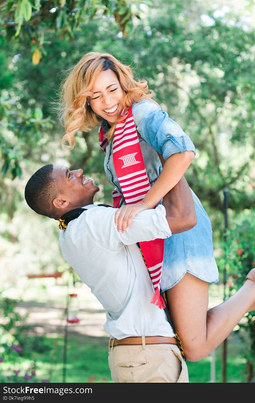 Photo of Man Lifting Woman Near Tree