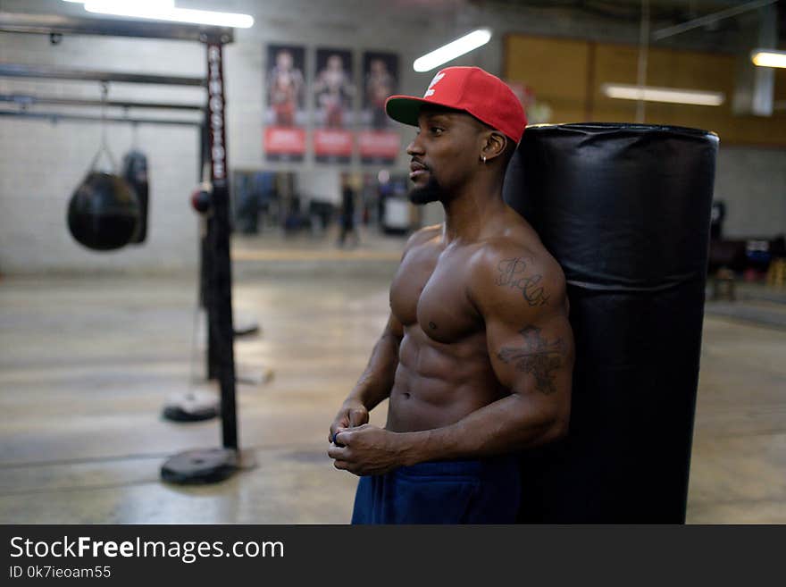 Man Leaning on Black Punching Bag