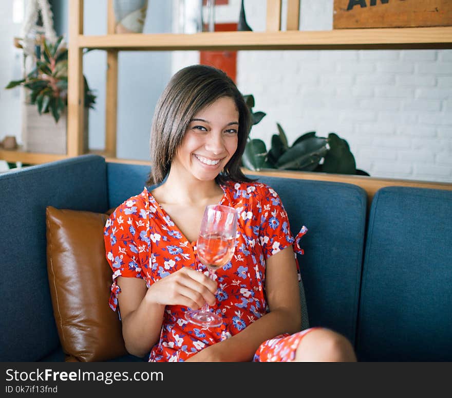 Woman Holding Wine Glass Sitting in Sofa