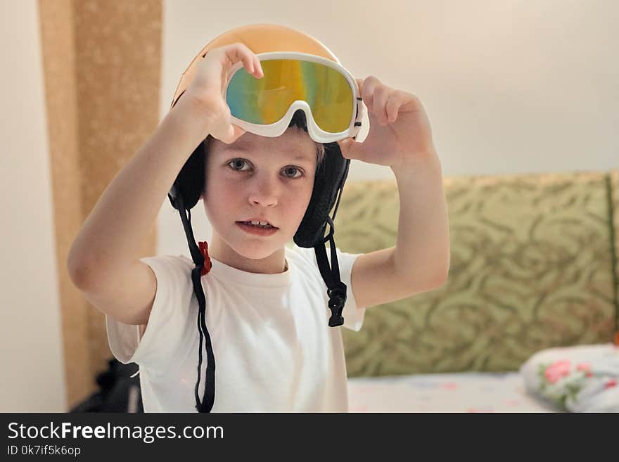 Portrait of laughing boy in skiing helmet playing at home