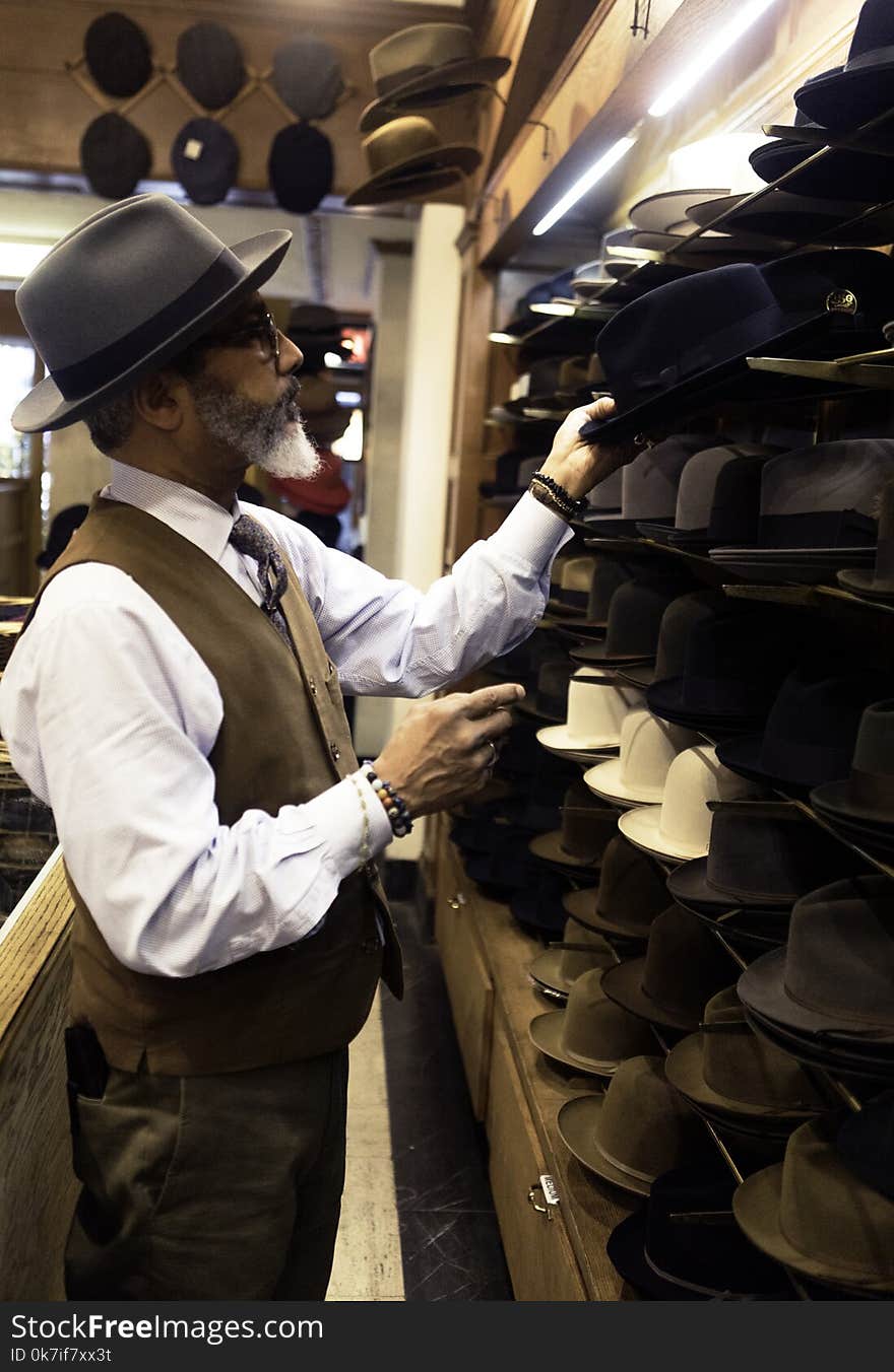 Man Picking Hats in Rack