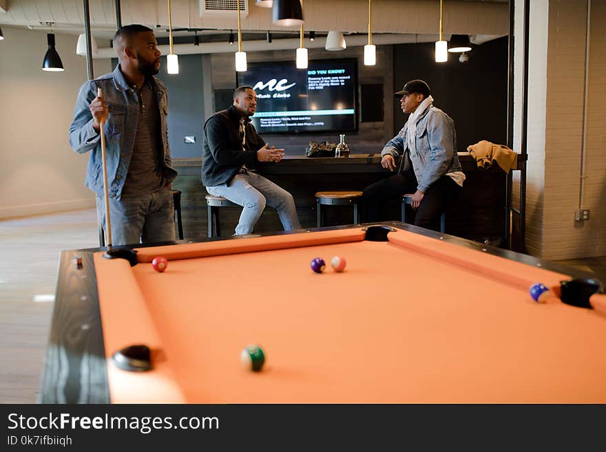 Man in Blue Denim Jacket Holding Cue Stick