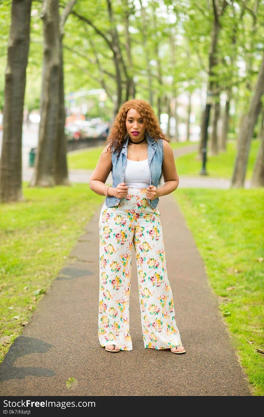 Woman in White Shirt with Denim Vest and Floral Pants