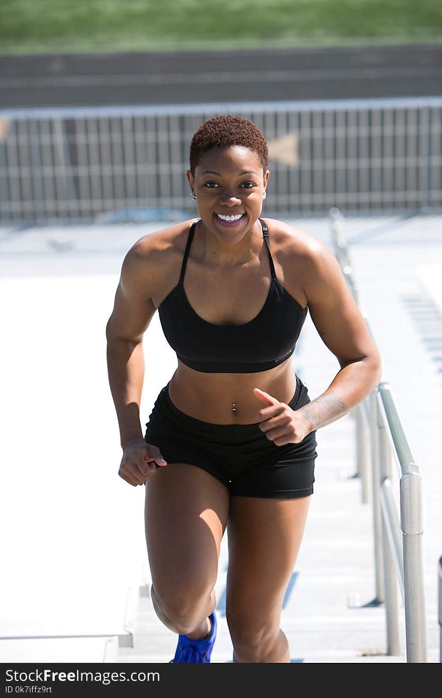 Woman Wearing Black Sports Bra and Jogger Shorts Smiling