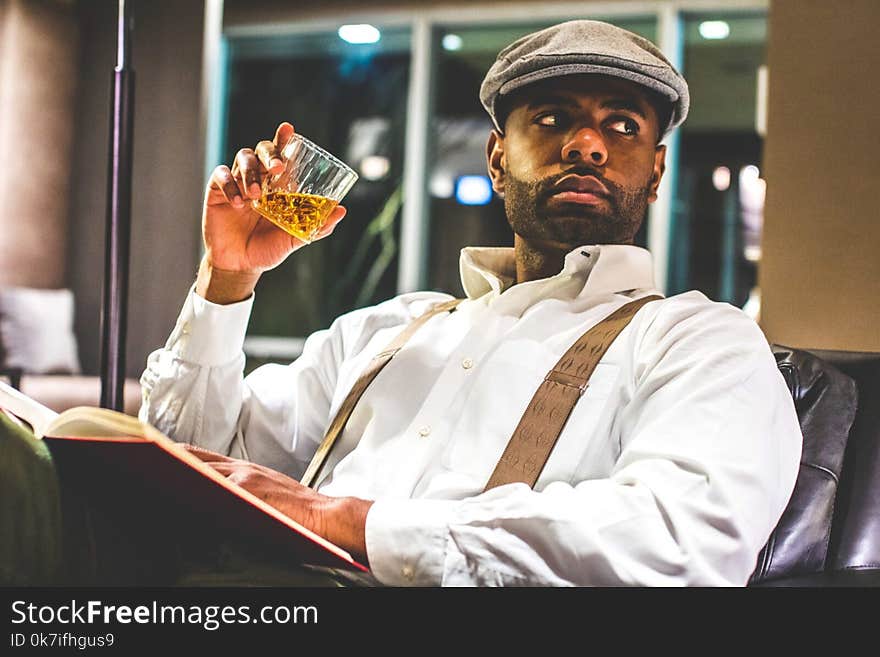 Man Sitting on Sofa Holding Rock Glass