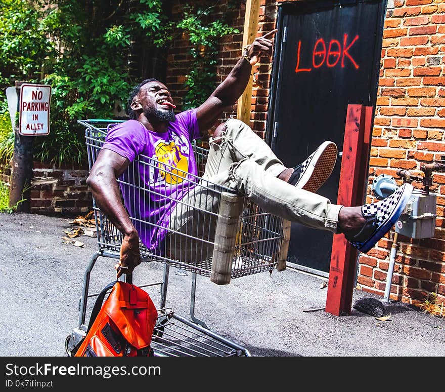 Man Sitting on Shopping Cart