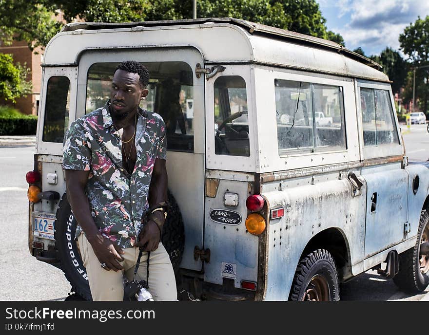 Man Stands Near White Land Rover Defender at Daytime