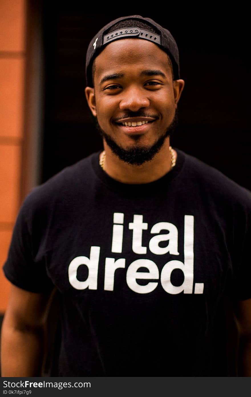 Smiling Man Wearing Black Snapback Cap and Black Crew-neck Shirt