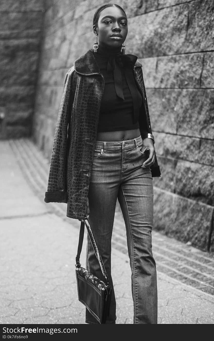 Woman in Jacket, Crop Top, and Pants Holding Bag