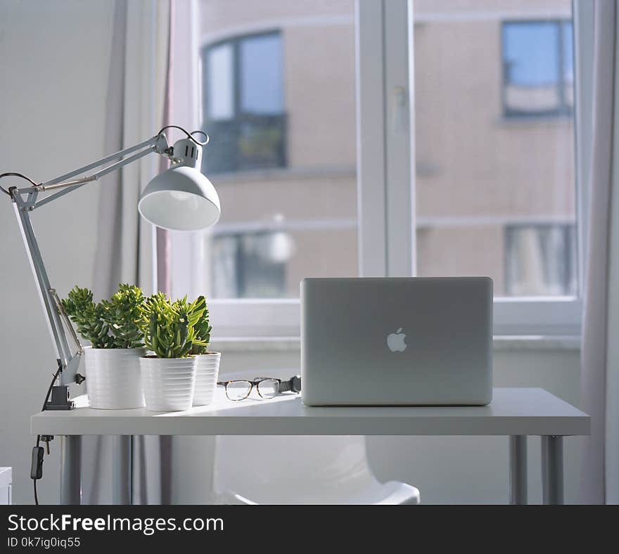 Silver Macbook Air and Goose Neck Lamp