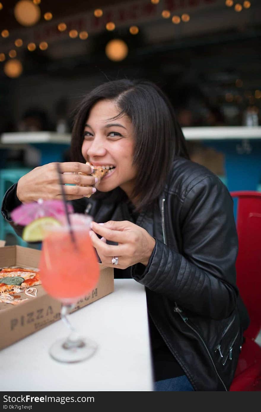 Woman Wearing Black Leather Jacket Eating Pizza