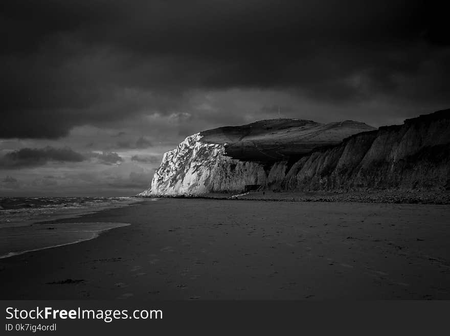 Mountain Near Beach Shore Under Dark Cloudy Sky