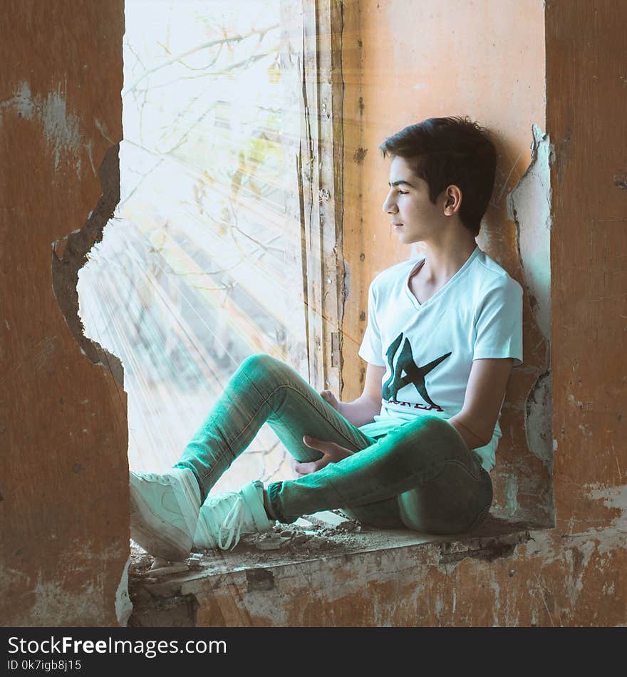 Boy Sitting Near Wall