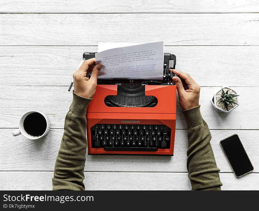 Person Operating Red Typewriter