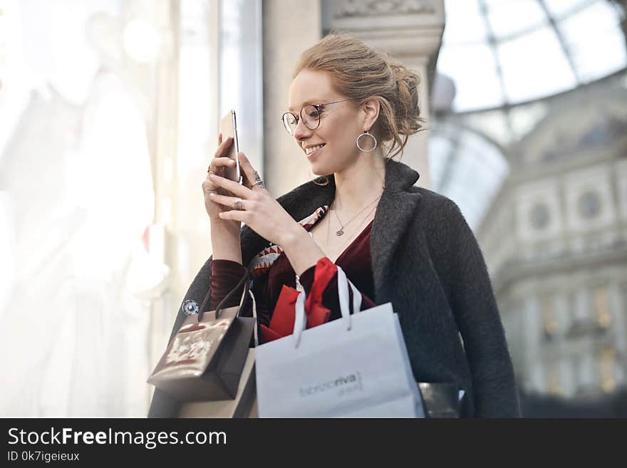 Woman Standing Near Wall Holding Phone