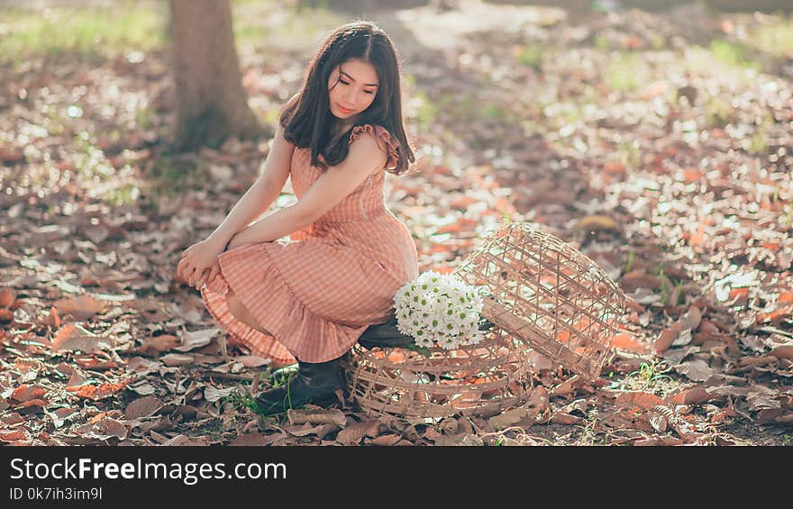 Woman Sitting Beside a Flower Bouquet