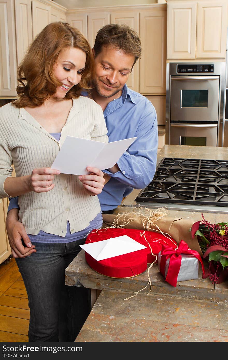 Husband giving his wife flowers and a card. Husband giving his wife flowers and a card.