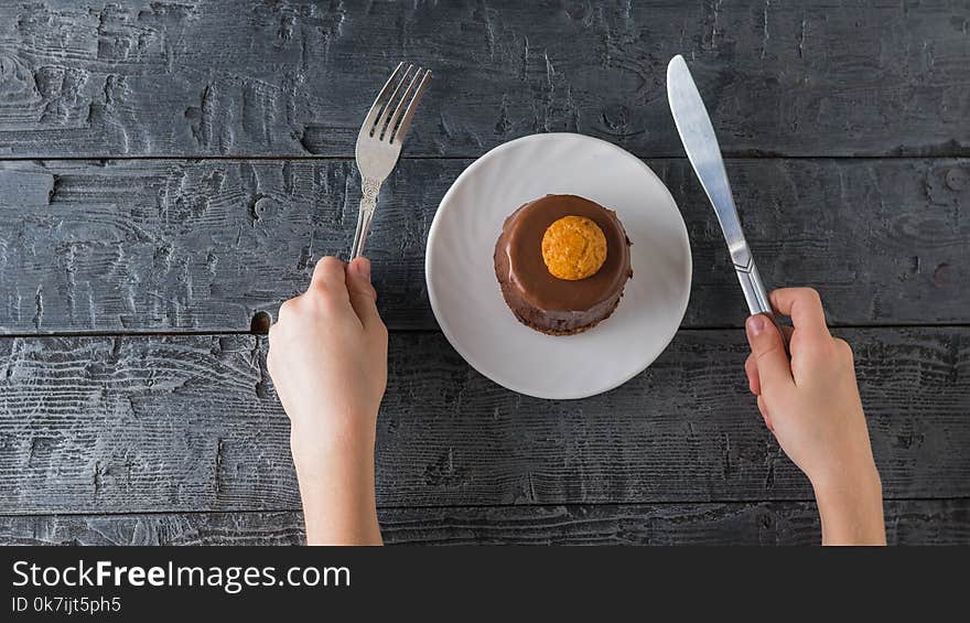 The child tries to eat dessert with a knife and fork.