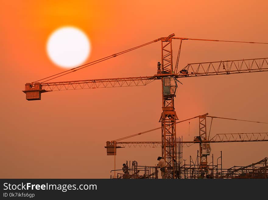 Building and crane under construction with sunrise or sunset sky background