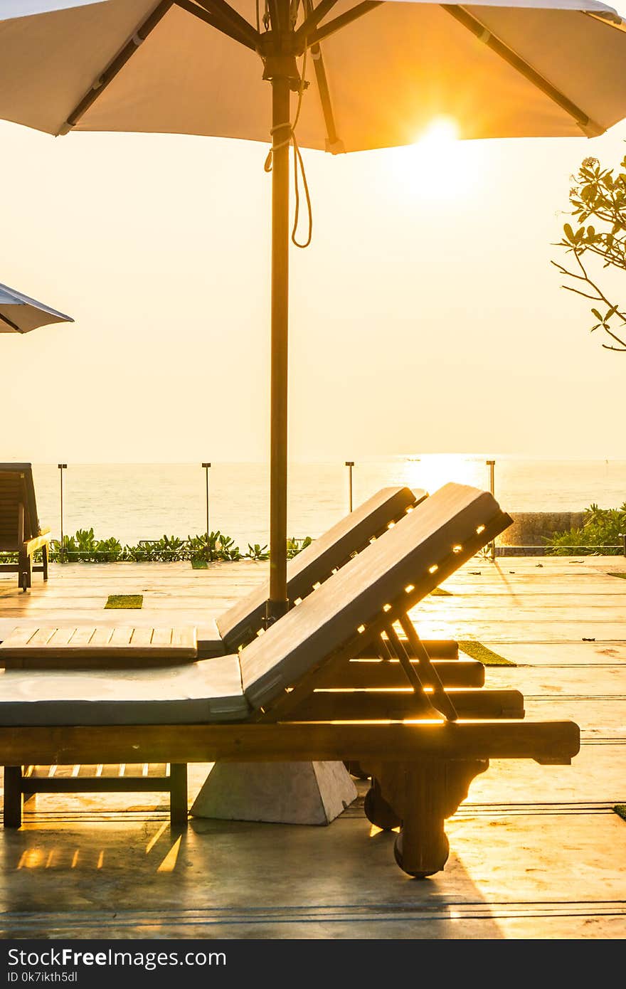 Beautiful umbrella and chair around swimming pool in hotel and r