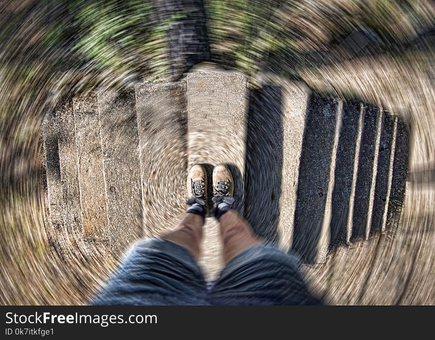 Hiker in boots at top of dual staircase with radial spin, concept image. Hiker in boots at top of dual staircase with radial spin, concept image
