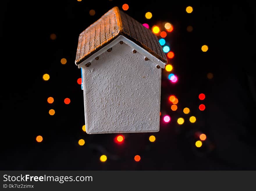 Little model house on a bokeh ligh ton a dark background. Little model house on a bokeh ligh ton a dark background